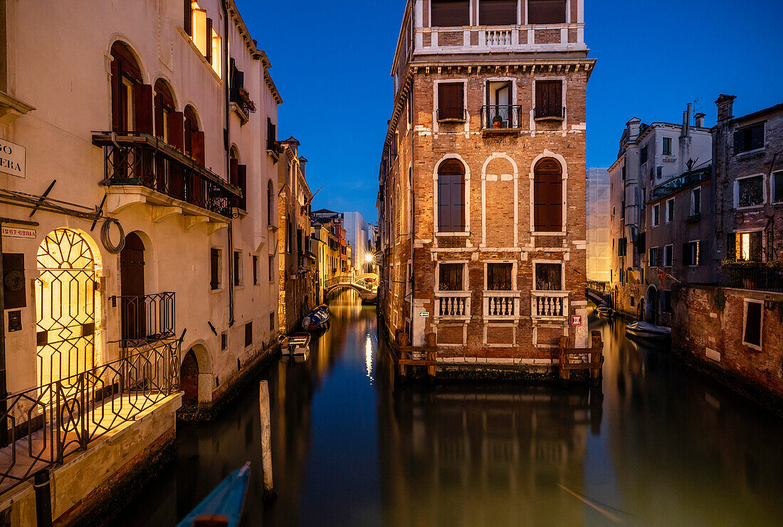Europa, Italien, Venedig. Zwei zusammenlaufende Kanäle und Gebäude bei Sonnenuntergang.