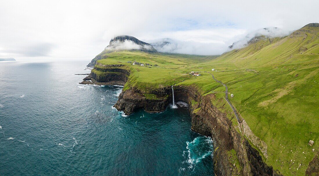 Aerial panoramic of waterfall and cliffs,Gasadalur,Vagar island,Faroe Islands,Denmark.