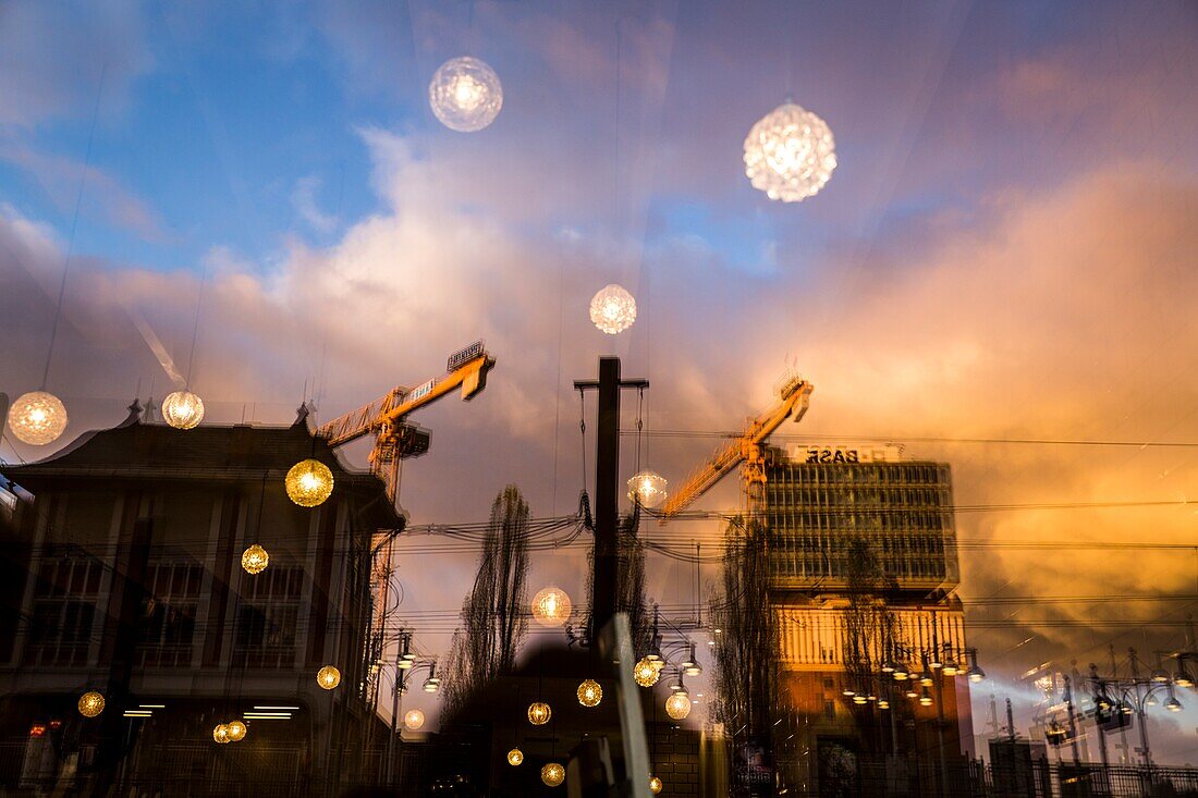 Ein dramatischer Himmel spiegelt sich im Fenster eines Restaurants in Berlin wider.