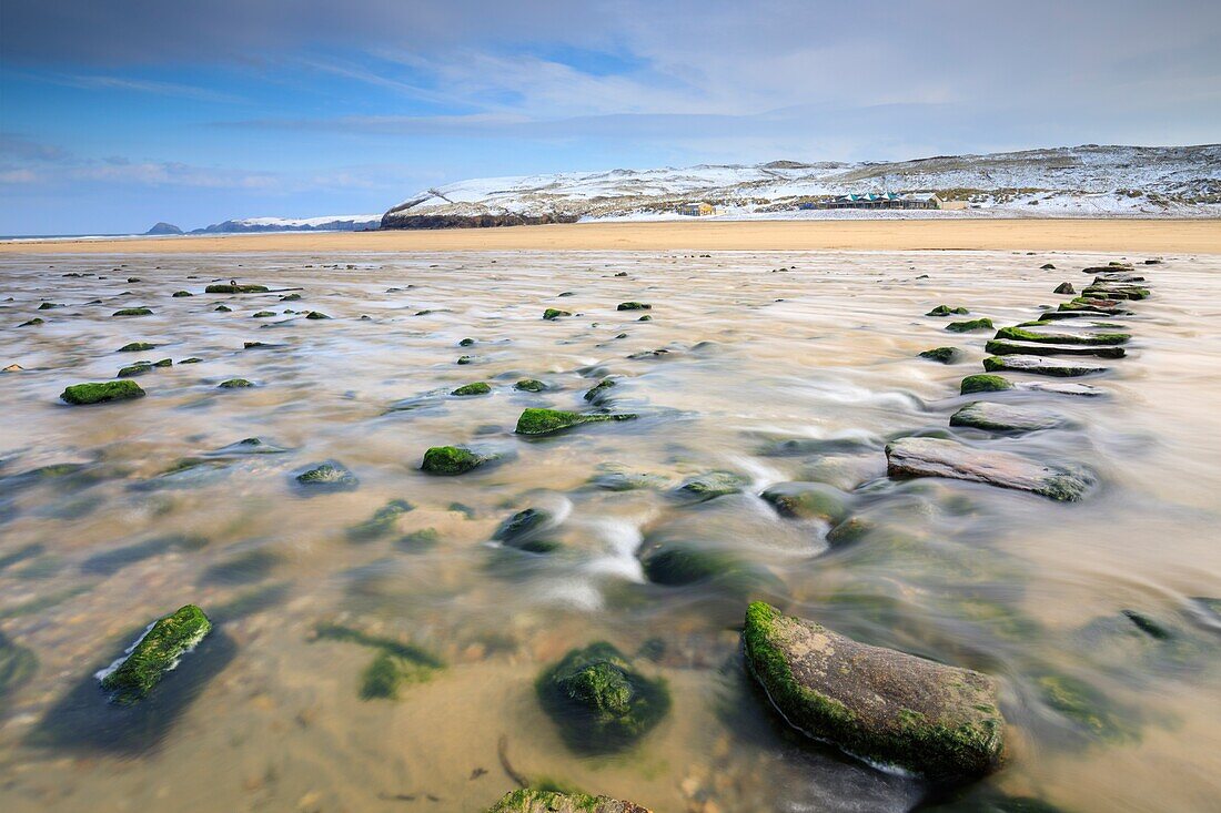 Die Trittsteine am Strand von Perranporth an der Nordküste von Cornwall, aufgenommen an einem Morgen Mitte März mit schneebedeckten Sanddünen in der Ferne.