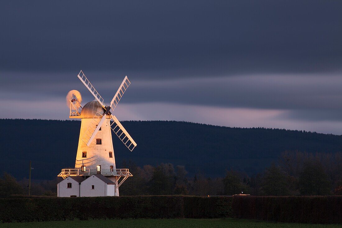 The floodlight illuminated Llancayo Windmill in the Usk Valley in South Wales captured from an adjacent footpath.