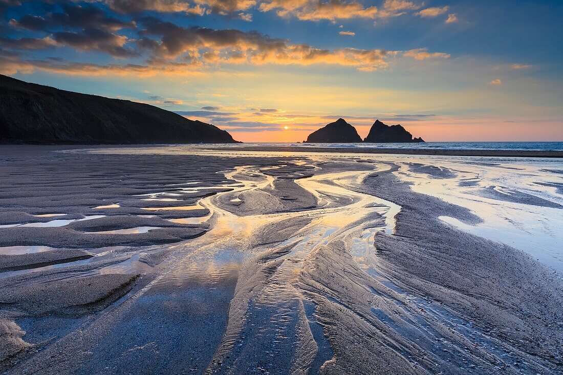 Sonnenuntergang im März am Strand von Holywell Bay an der Nordküste von Cornwall. Das Bild wurde sorgfältig komponiert, um das Beste aus dem Bach und den Wasserbecken am Strand herauszuholen.