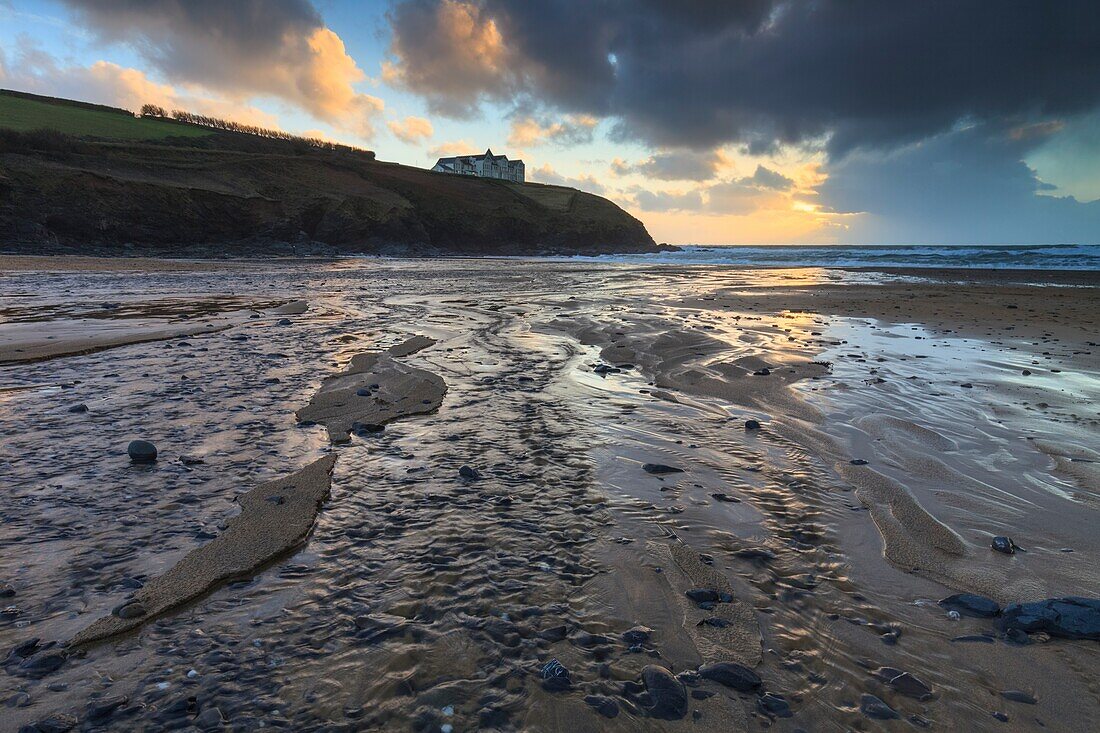 Der Bach, der über den Strand von Poldhu Cove auf Cornwalls Halbinsel Lizard fließt, wurde im Februar bei Sonnenuntergang aufgenommen.