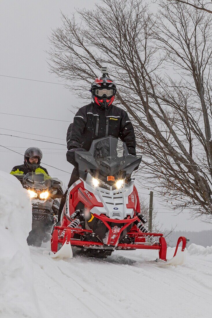 Grand Marais, Michigan - Schneemobilfahrer in einer kleinen Stadt am Lake Superior auf der oberen Halbinsel von Michigan.
