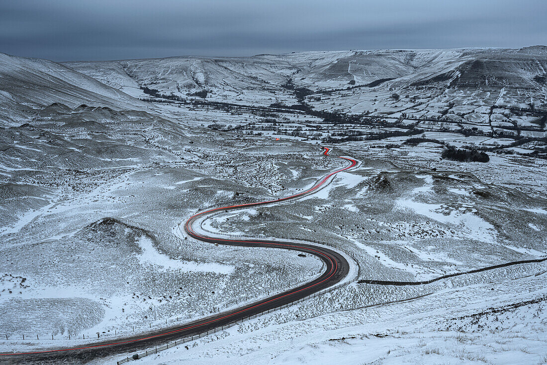 Car light trails on winding road in winter, Edale, Derbyshire, England, United Kingdom, Europe