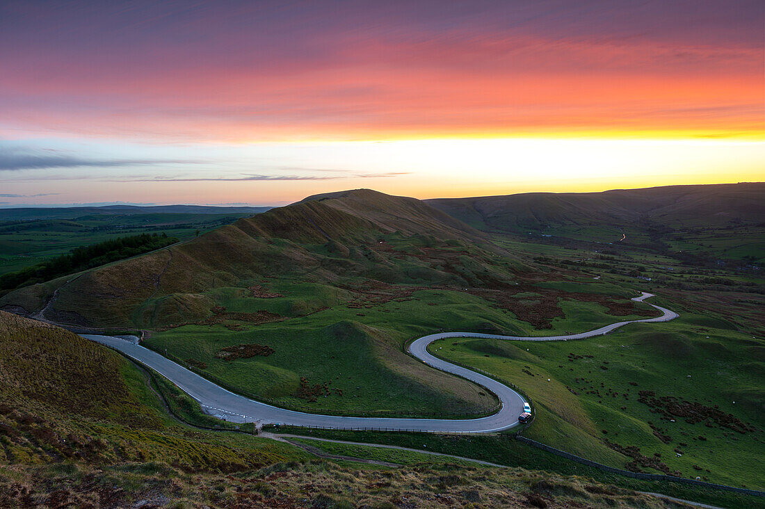 Sonnenuntergang am Rushup Edge mit kurvenreicher Straße nach Edale, Peak District, Derbyshire, England, Vereinigtes Königreich, Europa