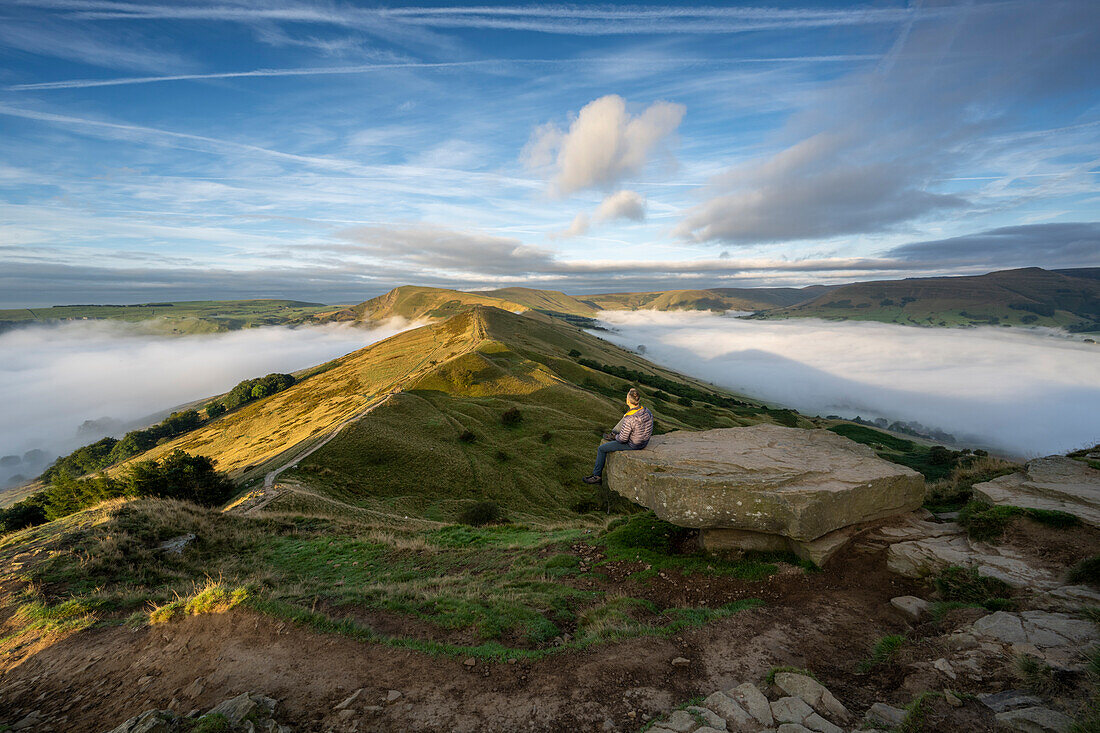 A walker sat looking across The Great Ridge and Mam Tor, Peak District, Derbyshire, England, United Kingdom, Europe