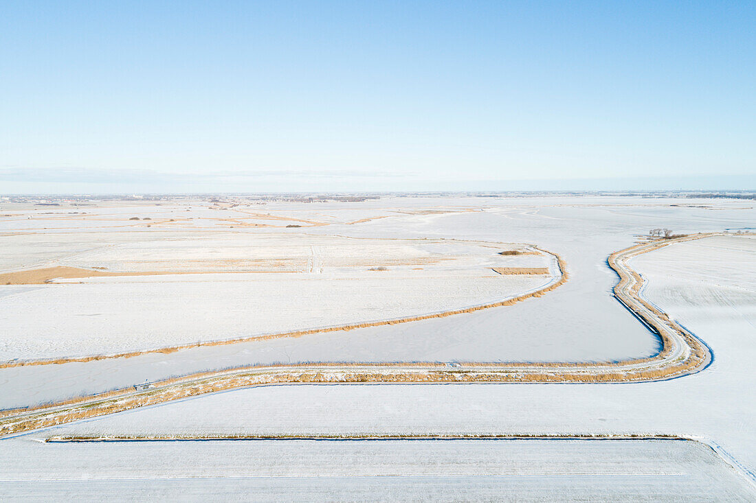 Netherlands, Broek, Aerial view of snow covered fields and canal