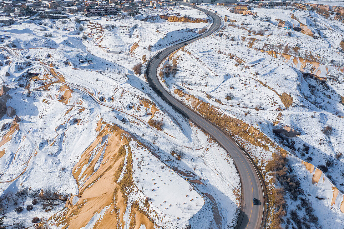 Turkey, Cappadocia, Aerial view of winding road in rocky landscape in Winter