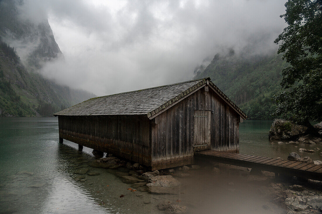 Deutschland, Bayern, Pier mit altem Holzgebäude am Obersee