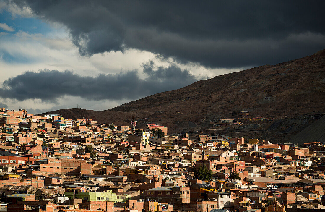 Bolivia, Potosi, Aerial view of city buildings and hill under storm clouds