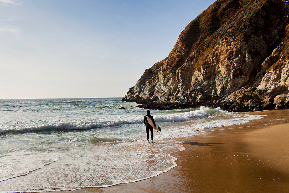 USA, California, Montara, Surfboard on beach at sunset