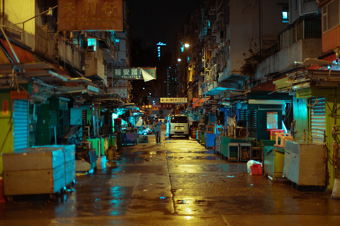 View of street and closed market stall at night in Hong Kong