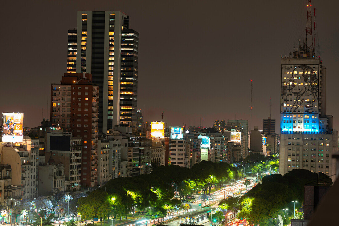 Elevated view of traffic driving on street with office buildings in city