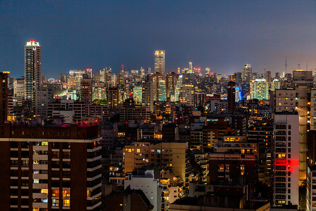 View of cityscape with residential buildings and office buildings at night