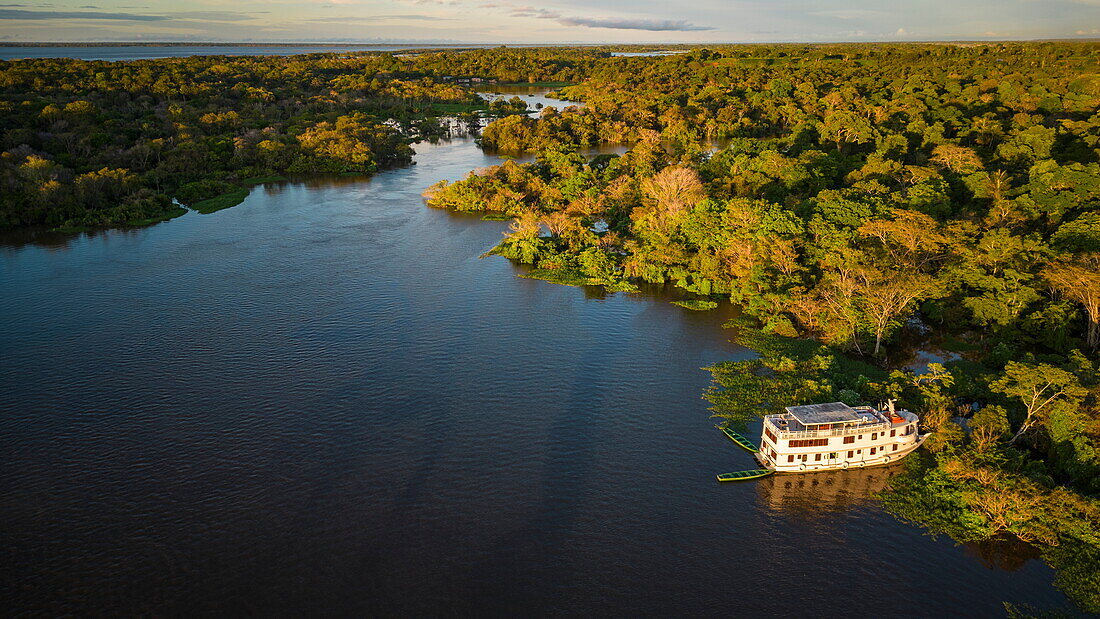 Luftaufnahme des Flussschiff MV Dorinha (ein traditioneller Amazonas-Dampfer), das an überflutete Bäume in der Flusslandschaft gebunden ist, nahe Manaus, Amazonas, Brasilien, Südamerika