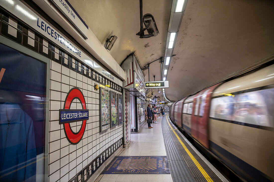 Leicester Square underground station with passing train, London, England, United Kingdom, Europe