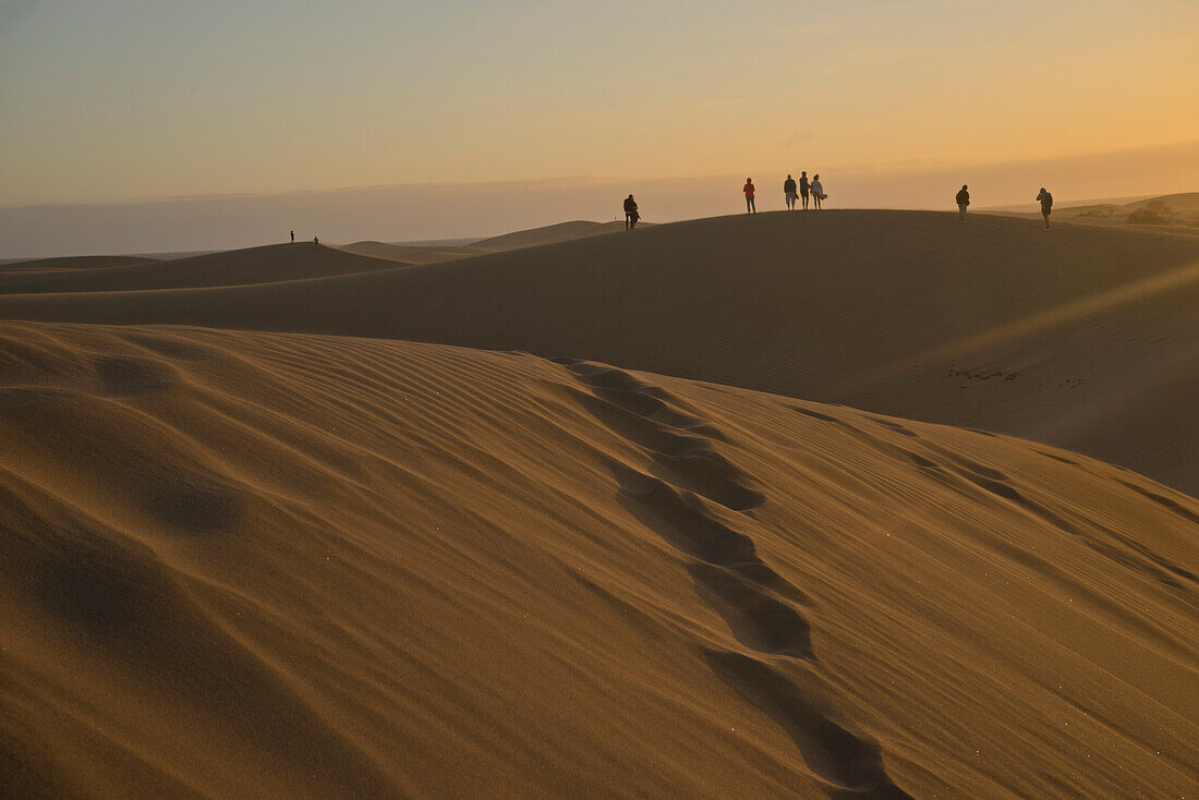 Junge Leute beobachten den Sonnenuntergang an den Sanddünen von Maspalomas, in der Nähe von Playa de los Ingleses, Gran Canaria, Kanarische Inseln, Spanien, Atlantik, Europa