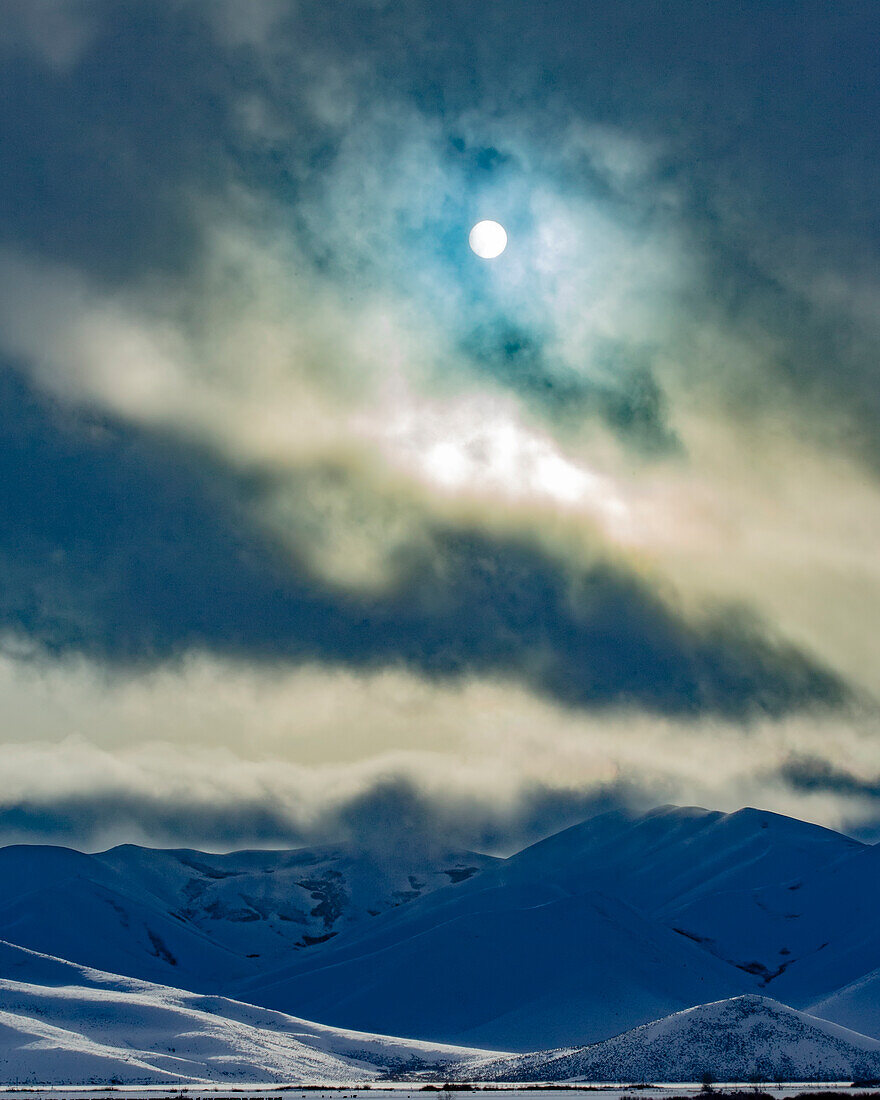 United States, Idaho, Bellevue, Sun shining through clouds above snowcapped mountains