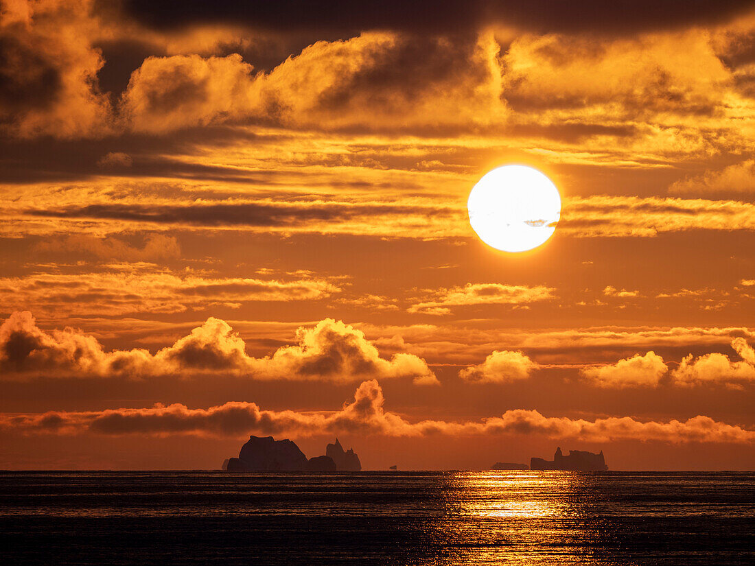 Sonnenuntergang auf einem großen Eisberg auf See in Richtung Peter I Island, Bellingshausensee, Antarktis, Polarregionen