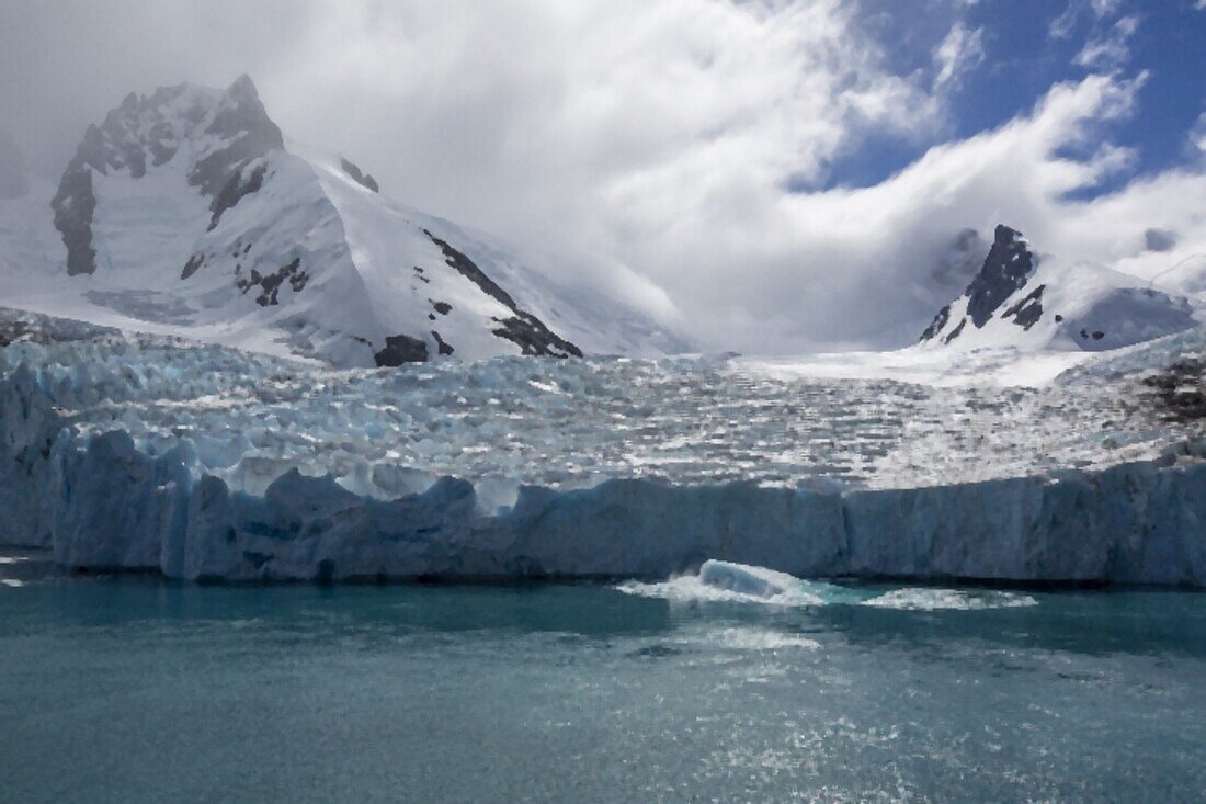 Ein Blick auf schneebedeckte Berge und ein Schütze vom Gletscher im Drygalski-Fjord, Südgeorgien, Südatlantik, Polarregionen