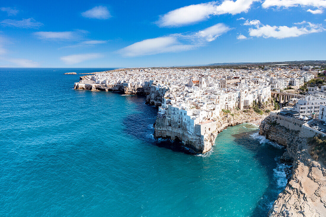 Aerial view of crystal sea surrounding Polignano a Mare on cliffs, province of Bari, Apulia, Italy, Europe