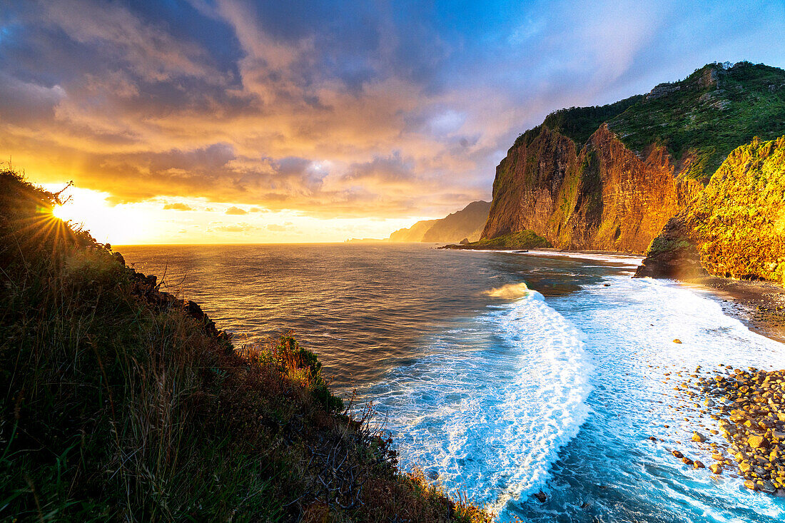 Malerischer Himmel im Morgengrauen über Wellen, die auf Klippen krachen, Insel Madeira, Portugal, Atlantik, Europa