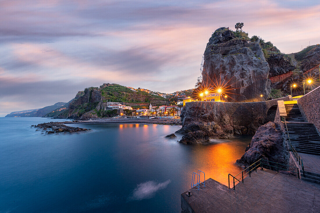 Dämmerung leuchtet über dem Küstenort Ponta do Sol, der vom Meer umspült wird, Insel Madeira, Portugal, Atlantik, Europa