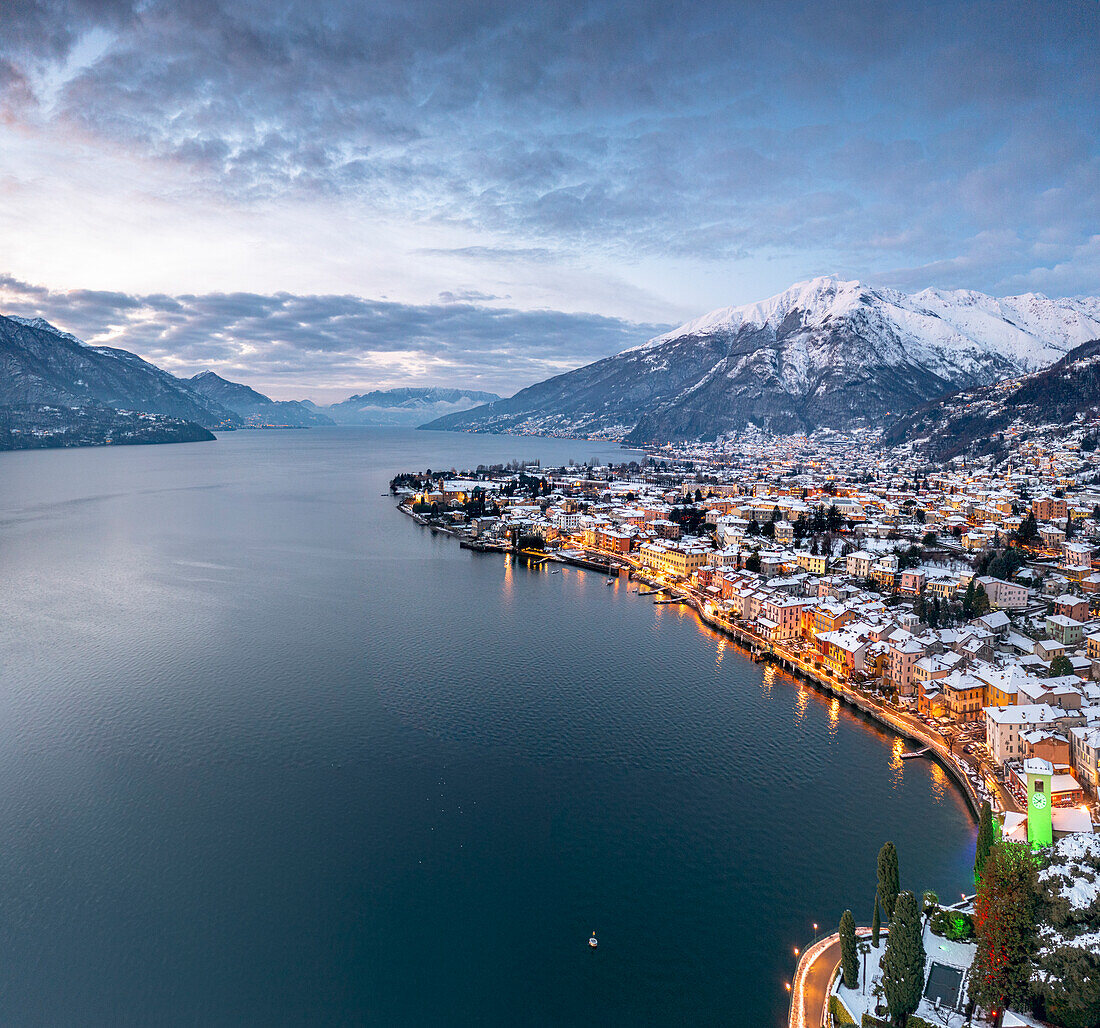 Winter sunrise over the illuminated lakeside town of Gravedona and snowy peaks, Lake Como, province of Como, Lombardy, Italian Lakes, Italy, Europe