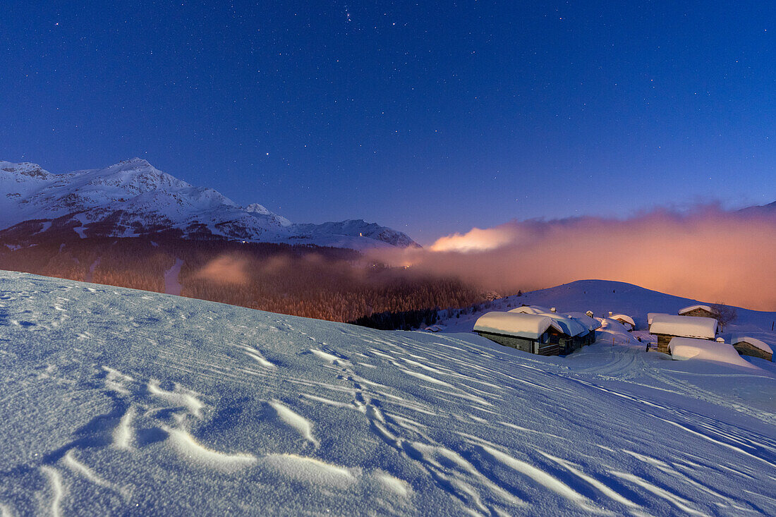 Mountain huts covered with snow under the starry winter sky, Andossi, Madesimo, Valchiavenna, Valtellina, Lombardy, Italy, Europe