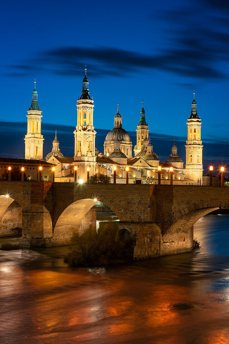 Basilica del Pilar Cathedral with stone bridge crossing Ebro River at night, Zaragoza, Aragon, Spain, Europe