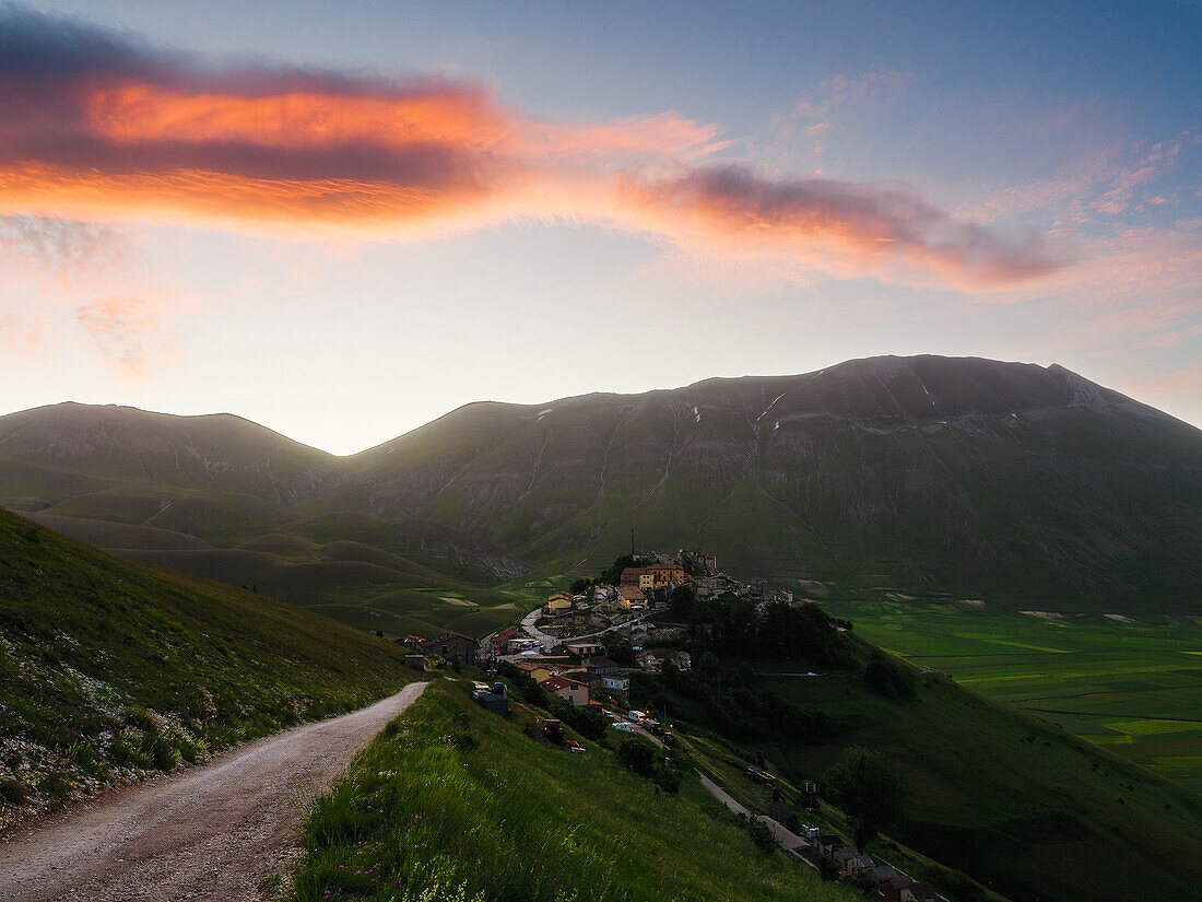 Blick auf das Dorf Castelluccio di Norcia mit Linsenfeldern und Bergen bei Sonnenaufgang, Perugia, Umbrien, Italien, Europa