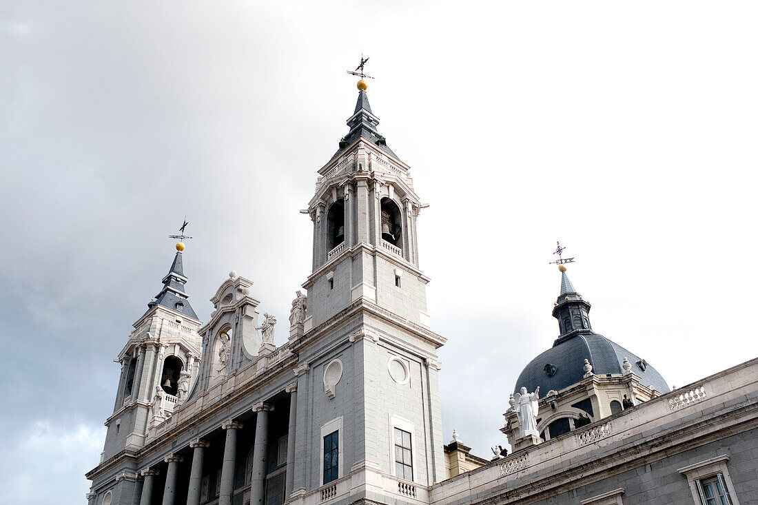 Niedrigwinkel-Ansicht der Glockentürme, Almudena-Kathedrale, gegen grauen Himmel, Madrid, Spanien