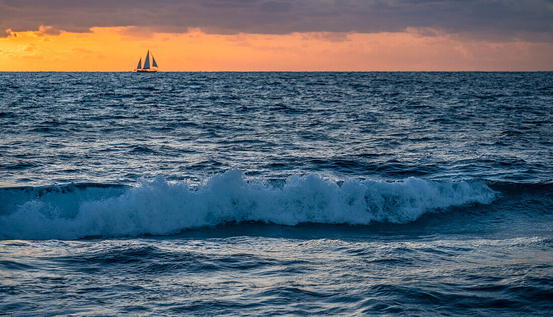 USA, Florida, Boca Raton, Sunrise over sea with silhouette of sailboat in distance