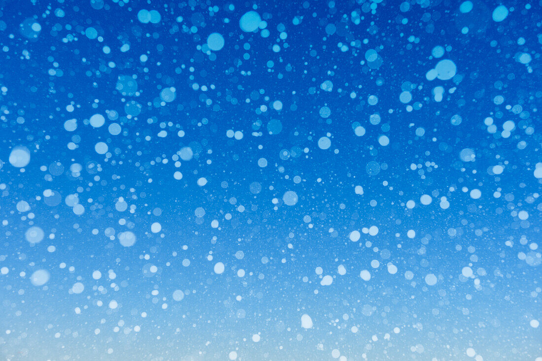 Falling snow against blue background