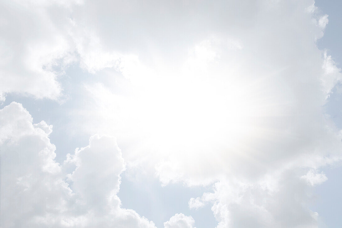 Sonne scheint durch weiße Wolken