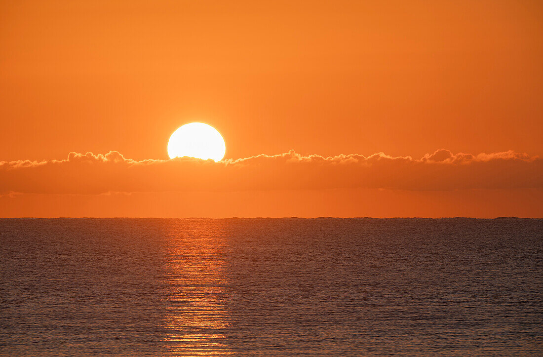 Flammender Sonnenaufgang im orangefarbenen Himmel über dem Ozean