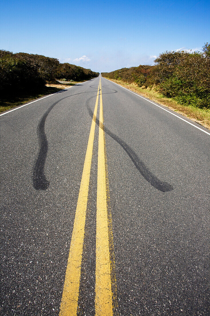 USA, Massachusetts, Reifenspuren und doppelte gelbe Linie auf leerer Straße