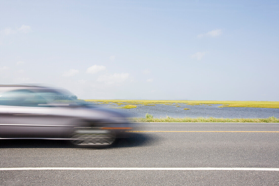 Virginia, Chincoteague, Auto auf der Straße verschwommen in Bewegung