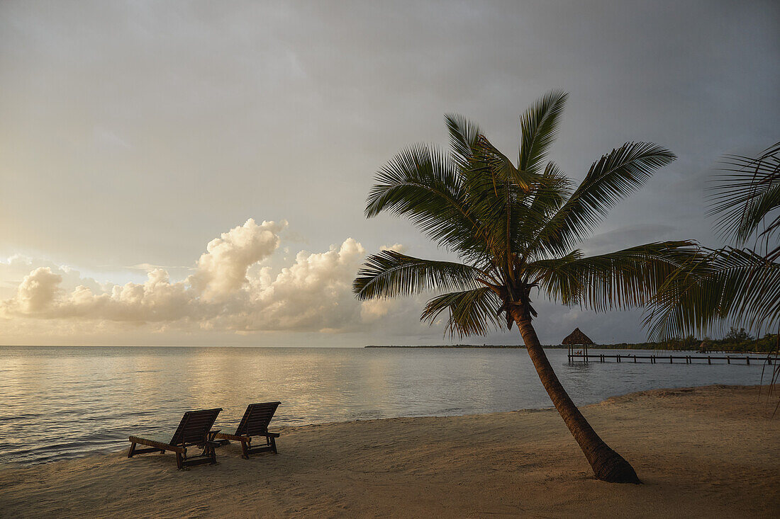 Belize, Placencia, Liegestühle am tropischen Strand bei Sonnenuntergang