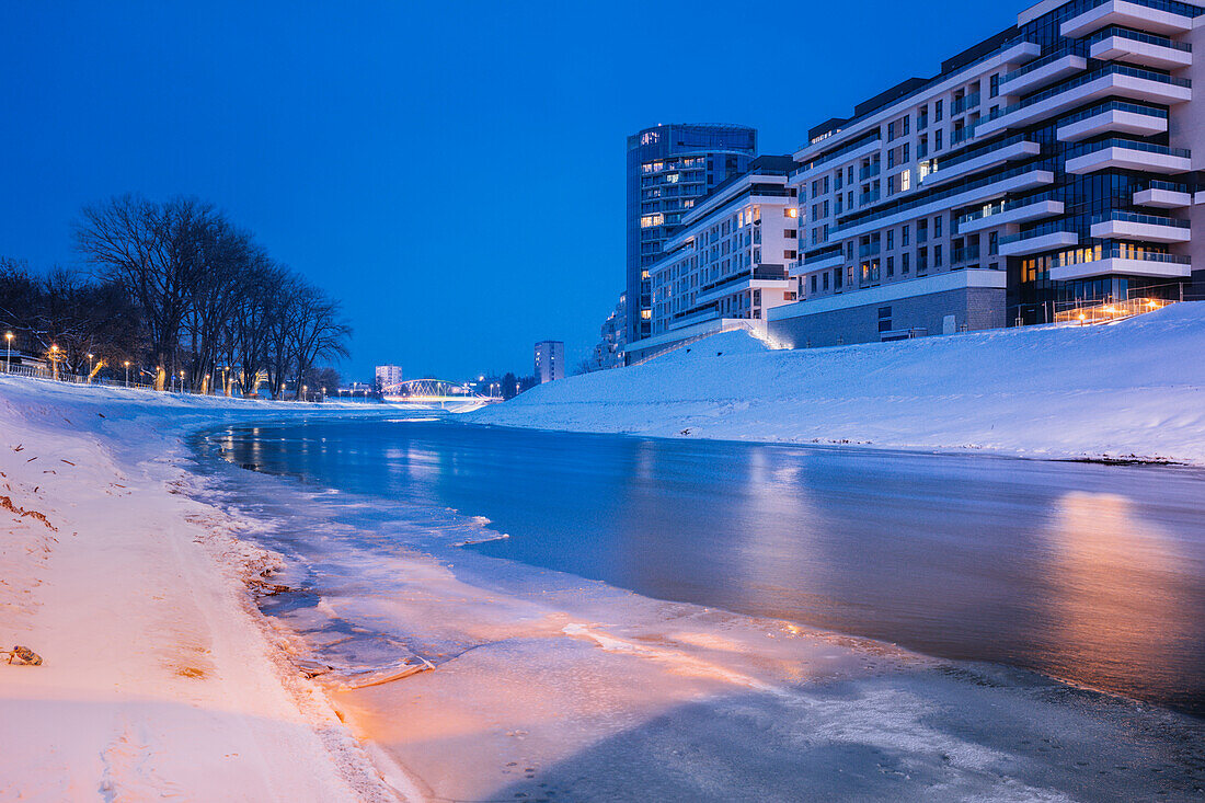 Poland, Subcarpathia, Rzeszow, Residential buildings at riverbank in winter