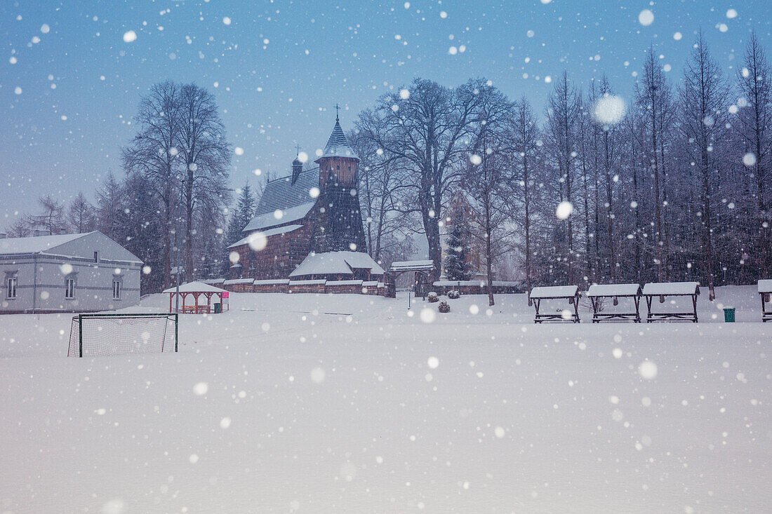 Poland, Subcarpathia, Trzcinica, Church at town square during winter snowfall