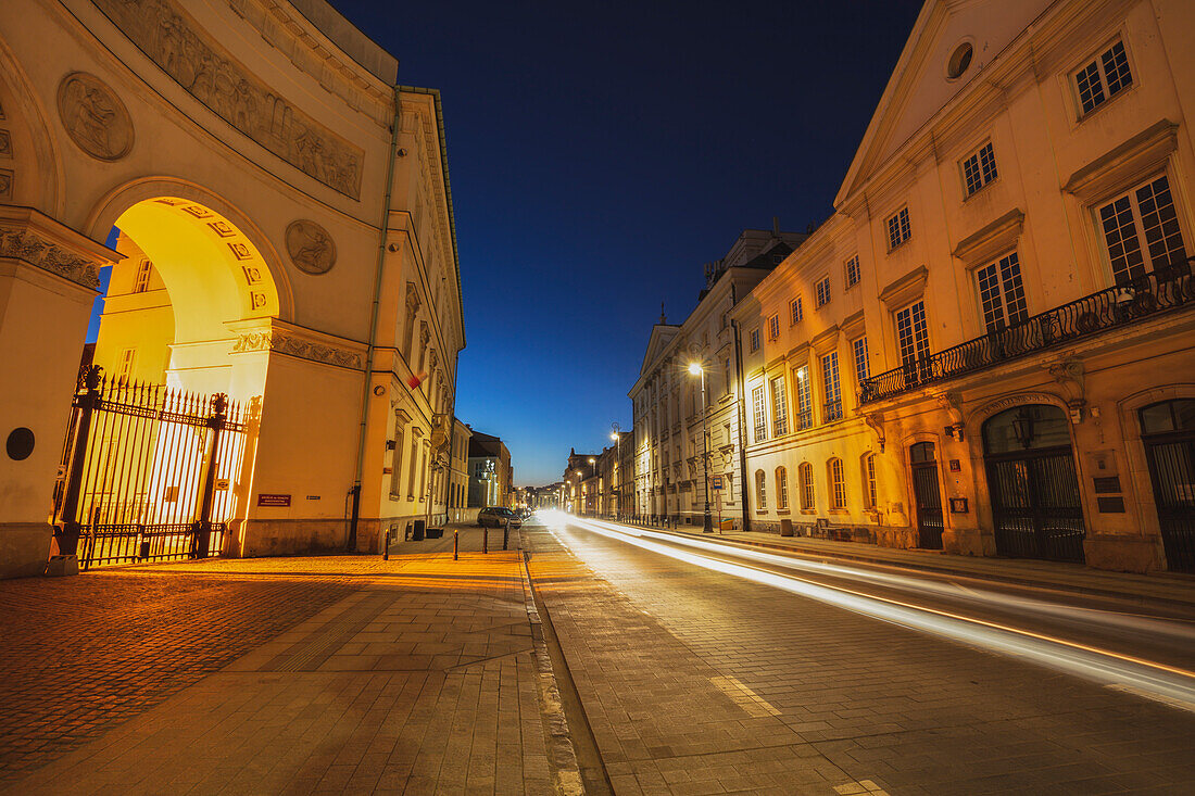 Polen, Masowien, Warschau, beleuchtete Stadtstraße mit historischen Gebäuden bei Nacht