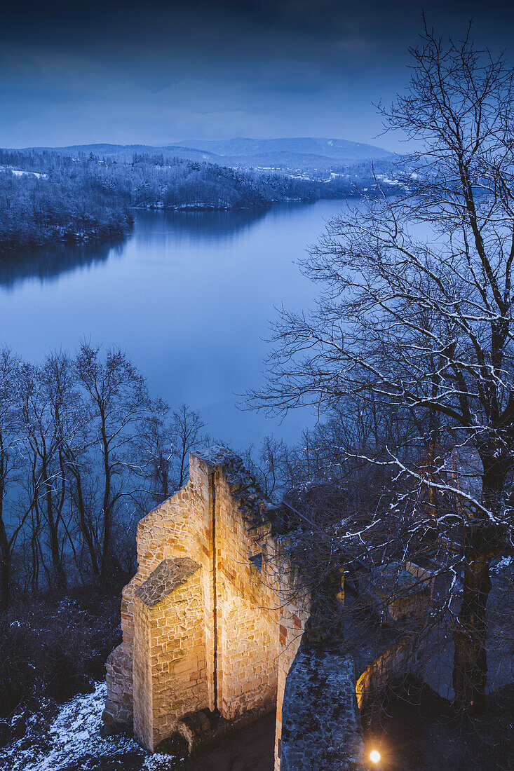 Poland, Lesser Poland, Dobczyce, Ruins of old castle in winter landscape by river