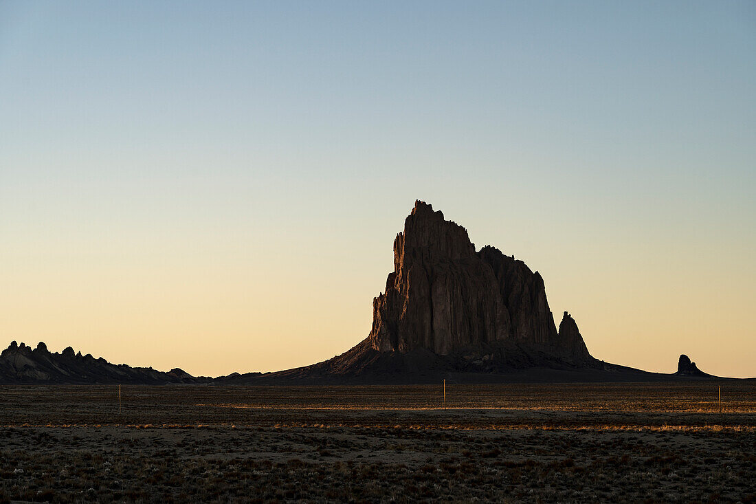 USA, New Mexico, Wüstenlandschaft mit Ship Rock bei Sonnenuntergang