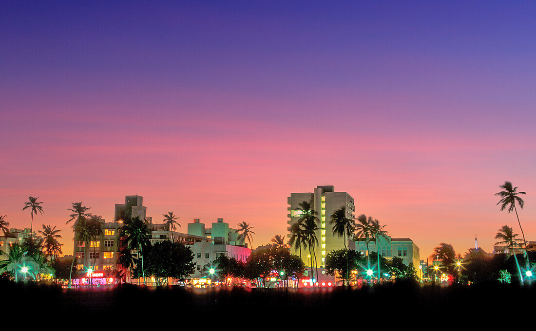 USA, Florida, Miami Beach, South Beach, beleuchtete Skyline der Stadt bei Sonnenuntergang