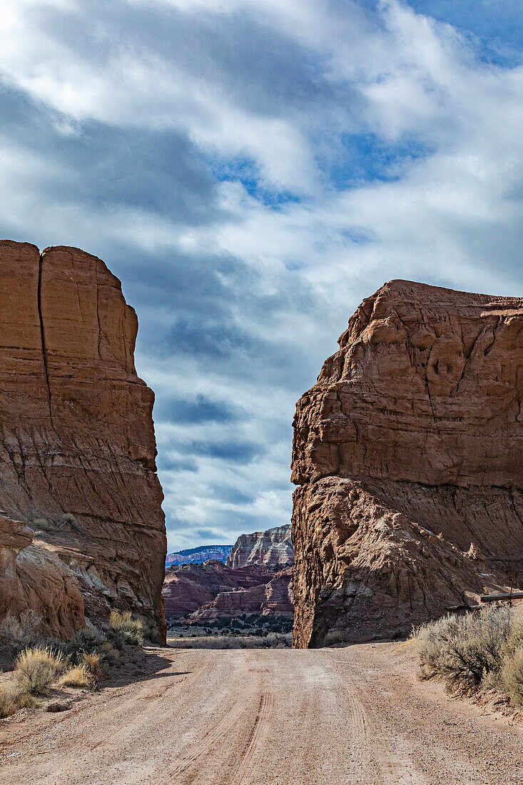 USA, Utah, Escalane, Dirt road between sandstone cliffs in Grand Staircase-Escalante National Monument