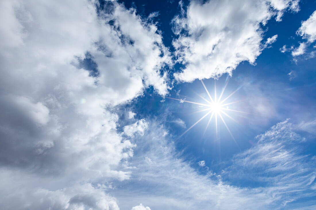 Sonnenfackel am blauen Himmel mit Wolken