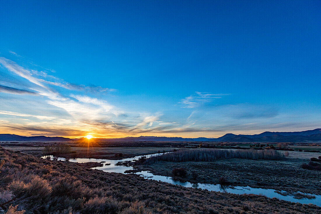 USA, Idaho, Bellevue, Sonnenuntergang hinter hügeliger Landschaft in der Nähe von Sun Valley