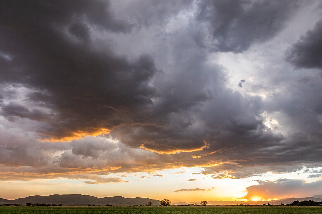 Usa, Idaho, Bellevue, Gewitterwolken über Felder bei Sonnenuntergang